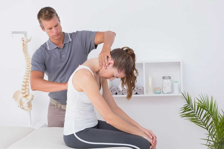 Chiropractor assessing an athlete’s injured knee with hands-on examination in a clinical setting.
